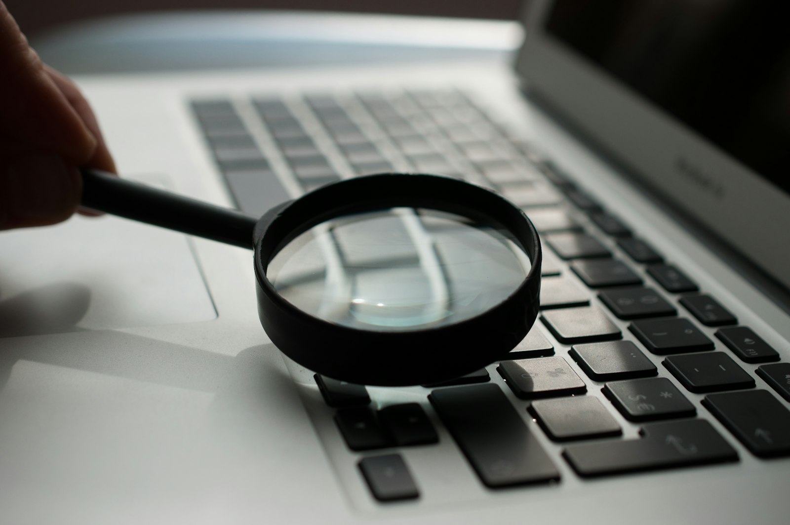 Lupa sobre el teclado de un portátil: diagnóstico y auditoría SEO de la web de una pyme