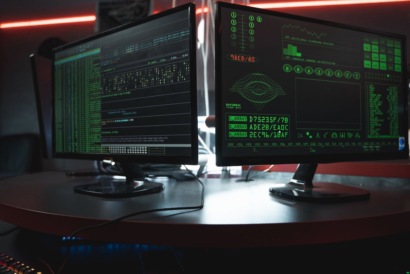 Monitores mostrando código en una pantalla oscura, representando una brecha de seguridad en un servidor